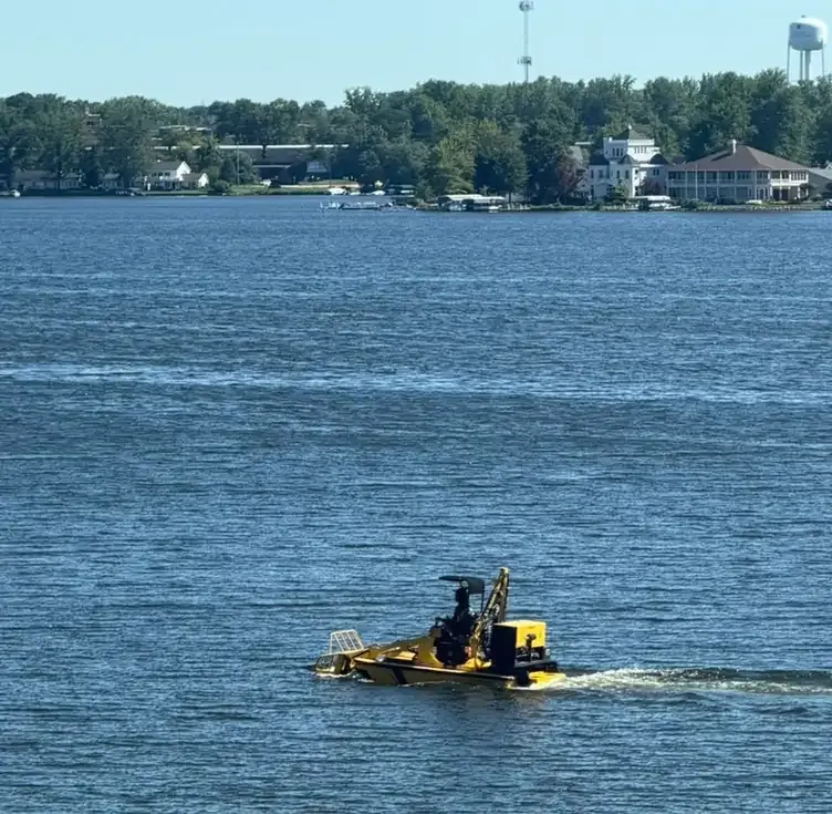 A mechanical weed harvester working on open water at Winona Lake